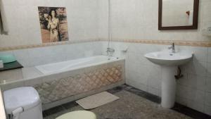 a bathroom with a sink and a tub and a toilet at De Puspa Residence Seminyak in Seminyak