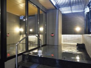 a bathroom with a shower and a tub with water at APA Hotel Saitama Shintoshin Eki-kita in Saitama
