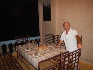Un uomo seduto a un tavolo con un piatto di cibo di A Secret Garden a Tinerhir