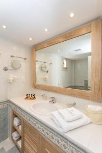 een badkamer met een wastafel en een grote spiegel bij Porto Naxos in Naxos Chora