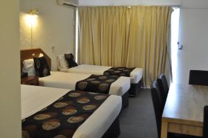 a hotel room with two beds and a television at Albury Burvale Motor Inn in Albury