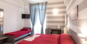 a bedroom with a red bed and a window at A&G Affittacamere in La Spezia
