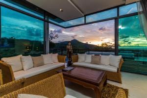 a living room with two couches and a table at Kamala Seaview villa by Lofty in Kamala Beach