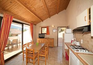 a kitchen and dining room with a table and chairs at Résidence Cabanaccia in Serriera