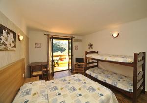 SerrieraにあるRésidence Cabanacciaのベッドルーム1室(二段ベッド2台付)、パティオへのドアが備わります。