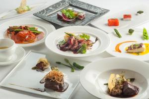 une table blanche avec des assiettes de nourriture dans l'établissement Restaurant & Hotel Traumerei, à Hakuba