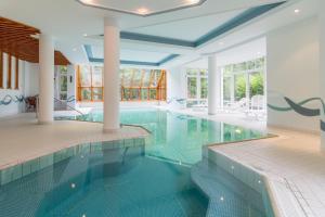 een zwembad in een huis met een blauw plafond bij Hotel Sauerbrey in Osterode