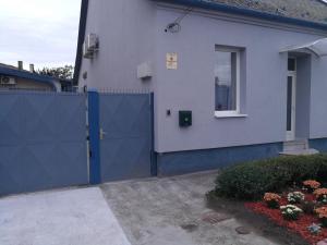 a blue gate in front of a house at Nádor Apartman in Győr