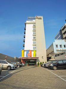 a parking lot with cars parked in front of a building at Amaris Hotel Pancoran in Jakarta