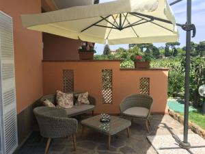 a patio with a table and chairs and an umbrella at VillaGiò B&B in Frascati