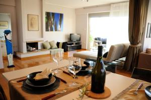 salon ze stołem i butelką wina w obiekcie Glyfada Luxury w Atenach