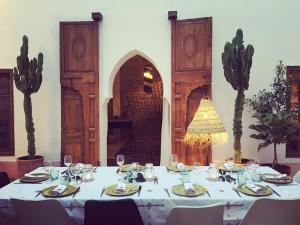 a table with a white table cloth and glasses at Riad UP in Marrakesh