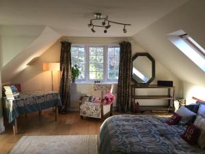 a attic bedroom with a bed and a mirror at Hurstbourne in Camberley