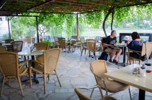 two people sitting at tables in a restaurant at Hovolo Hotel Apartments in Neo Klima