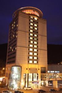 un grande edificio con auto parcheggiate in un parcheggio di City Hotel Suhl a Suhl