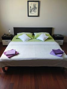 a bedroom with a large bed with purple pillows at Apartments Kristina in Klenovica