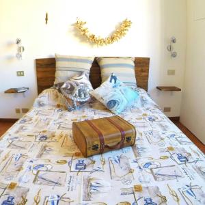 ein Bett mit einer Decke mit einem Koffer drauf in der Unterkunft La Bitta Sul Molo in Genua