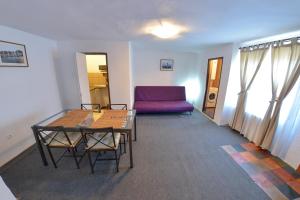 a living room with a table and a purple couch at Apartment Gabriel in Sibiu