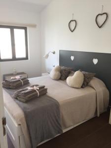 1 dormitorio con 1 cama grande con corazones en la pared en Casa d' amare, en Playa del Águila