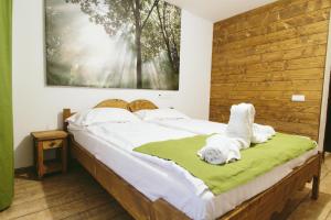 a bedroom with a large bed with a wooden headboard at Hotel Superski in Cavnic
