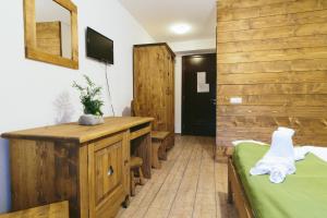 a room with a bed and a wooden wall at Hotel Superski in Cavnic