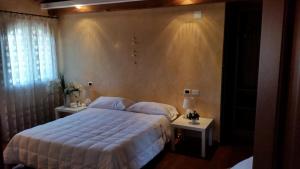 a bedroom with a large bed and two night stands at B&B Casa Sofia in San Pièr dʼIsonzo