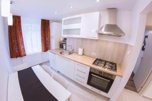 eine Küche mit weißen Schränken und einem Herd mit Backofen in der Unterkunft Apartment GoodMood2 with free parking in Zagreb