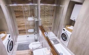 ein Bad mit einer Dusche, einem WC und einer Waschmaschine in der Unterkunft Apartment GoodMood2 with free parking in Zagreb + 16 Fotos