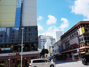 a white car driving down a city street with buildings at Hotel Abest Naha Kokusai Street in Naha