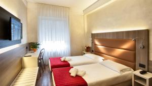 una camera d'albergo con due letti e una panca rossa di Hotel Gamma a Milano