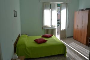 a bedroom with a green bed with two red pillows on it at Appartamenti In Residence Zoe in Roseto degli Abruzzi