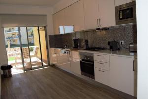 a kitchen with white cabinets and a stove top oven at Albufeira Marina Gold in Albufeira
