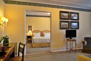 una camera d'albergo con letto e specchio di Hotel Avenida Palace a Lisbona