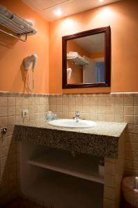 a bathroom with a sink and a mirror at Apartamentos Ripoll Ibiza in Ibiza Town