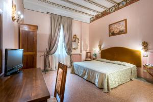 1 dormitorio con cama, mesa y TV en Hotel San Marco Sestola, en Sestola