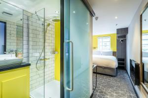 a bathroom with a shower and a bed in a room at KM Hotel in Edinburgh