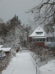 uma casa com uma entrada coberta de neve em frente a uma casa em Alte Häuslerei em Boltenhagen