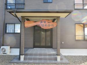 una puerta delantera de una casa con un cartel en ella en Minshuku Iwakawa, en Yakushima