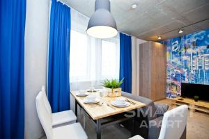 エカテリンブルクにあるSmart Apartのダイニングルーム(青いカーテン、テーブル、椅子付)