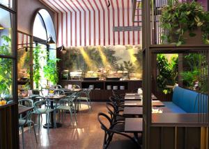 restauracja ze stołami, krzesłami i roślinami w obiekcie Hotel Sanpi Milano w Mediolanie
