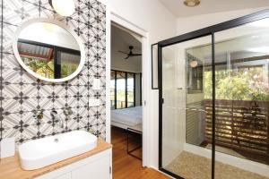 a bathroom with a shower and a sink and a mirror at Tallaringa Views in Alstonville