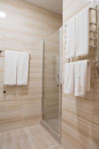 a bathroom with a shower with white towels at Malon apartments in Odesa
