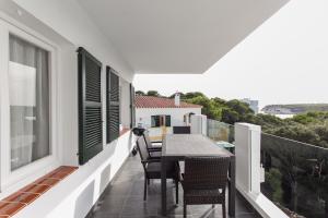 a balcony with a table and chairs on it at Apartamentos Gama in Cala Galdana