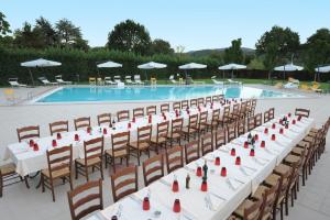 ein langer Tisch und Stühle vor einem Schwimmbecken in der Unterkunft Park Hotel Ripaverde in Borgo San Lorenzo