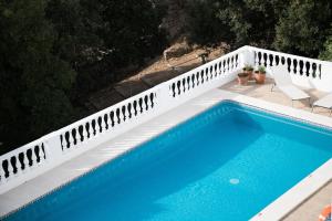 a swimming pool next to a white fence at Apartamentos Gama in Cala Galdana