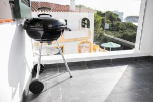 a grill on a stand in a kitchen with a window at Apartamentos Gama in Cala Galdana