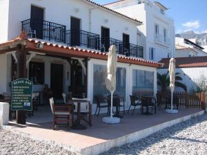 ein Restaurant mit Stühlen und Sonnenschirmen vor einem Gebäude in der Unterkunft Long Beach Kokkari Samos in Kokkari + 19 Fotos