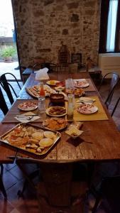 a wooden table with many plates of food on it at Residenza d'Epoca Borgodifiume in Fiumefreddo Bruzio