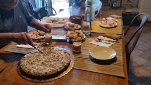 a man cutting a cake on a wooden table at Residenza d'Epoca Borgodifiume in Fiumefreddo Bruzio