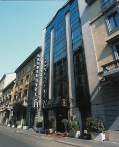 wysoki budynek ze szklanymi oknami przy ulicy miejskiej w obiekcie Hotel Sanpi Milano w Mediolanie